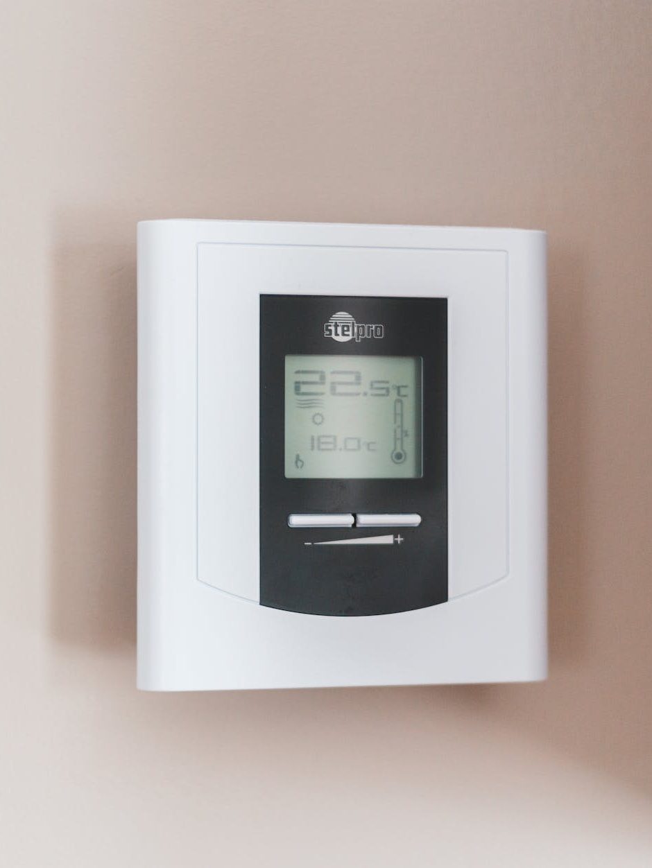 white thermostat hanging on the wall